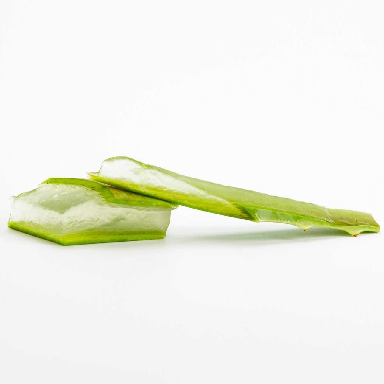 Two fresh slices of green aloe vera showing the translucent inner gel, set against a plain white background.